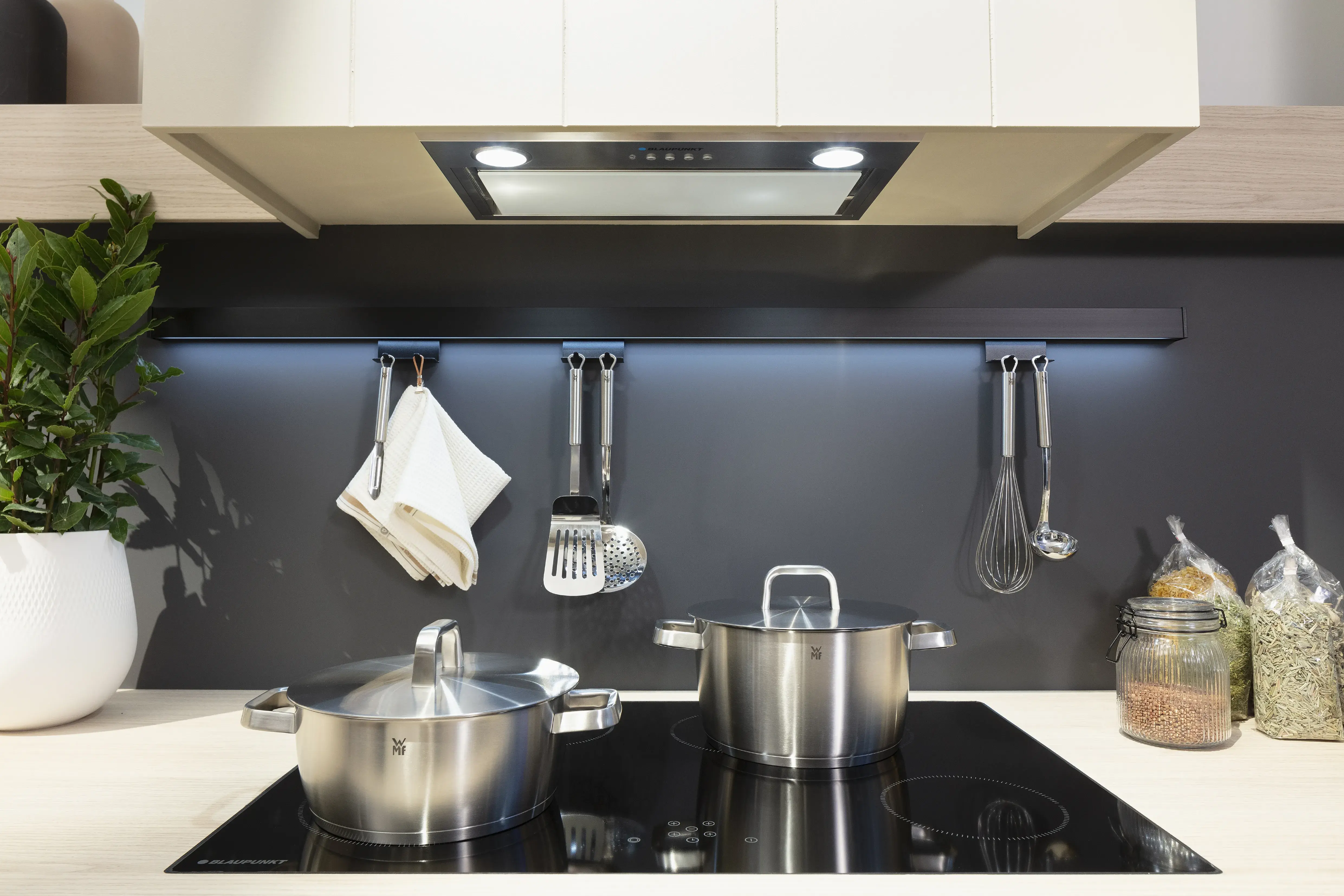 Kochfeld und Dunstabzug mit Töpfen. 