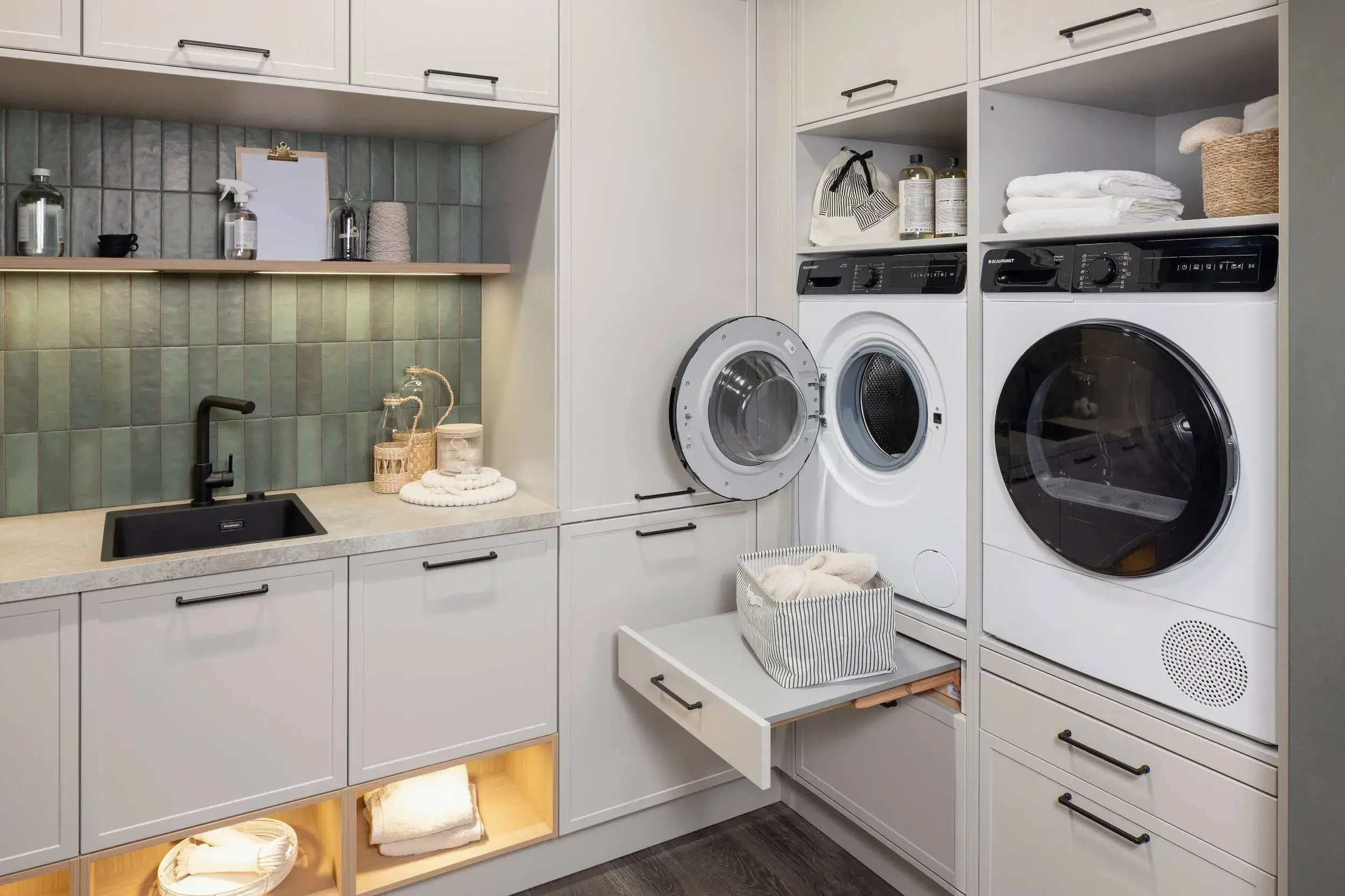 HÄCKER Systemat Hauswirtschaftsraum Lichtgrau Kalkstein - Detailansicht ergonomisch verbaute Waschmaschine und Trockner