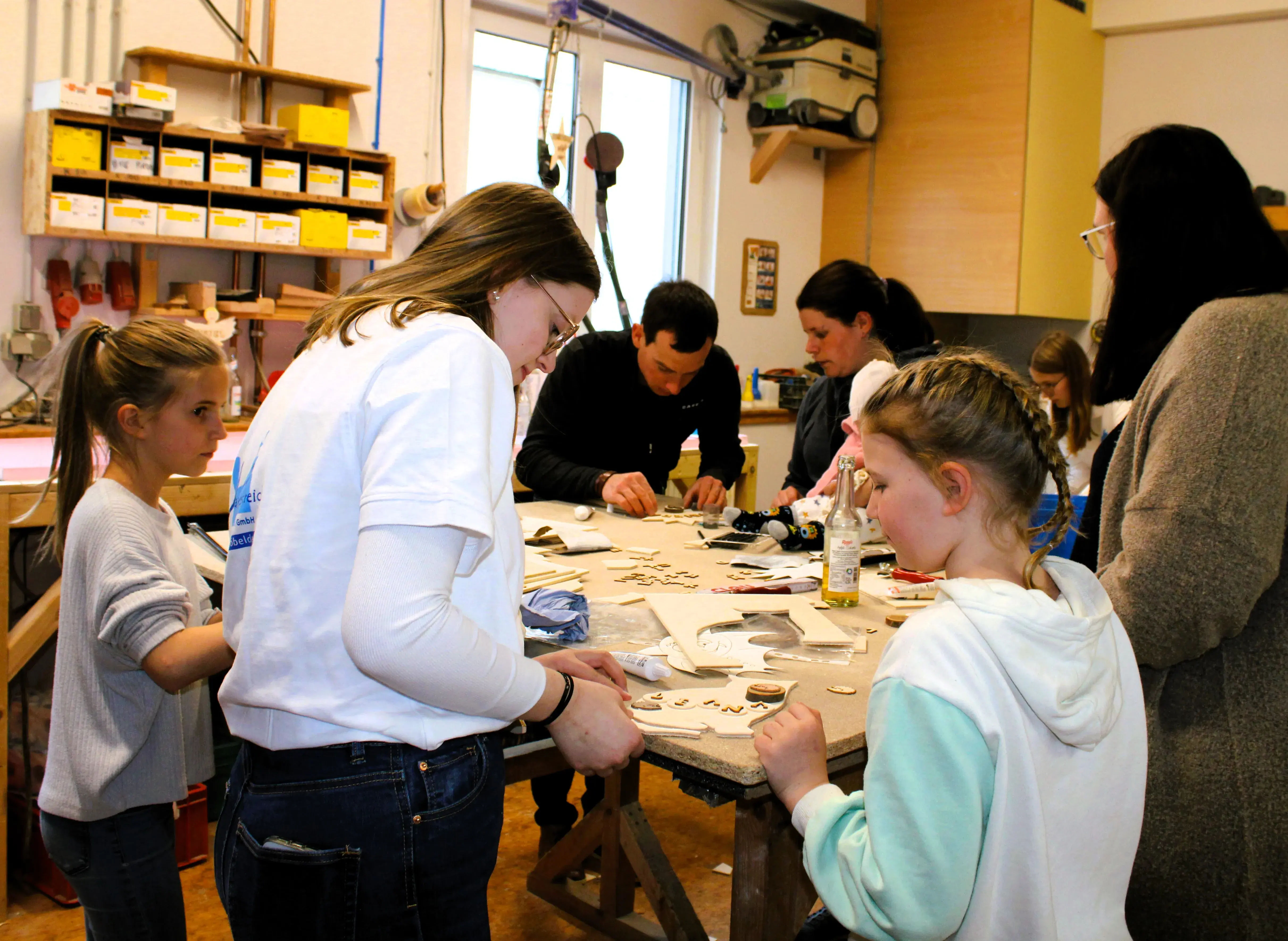 Menschen arbeiten gemeinsam an einem Bastelprojekt in einer Werkstatt.
