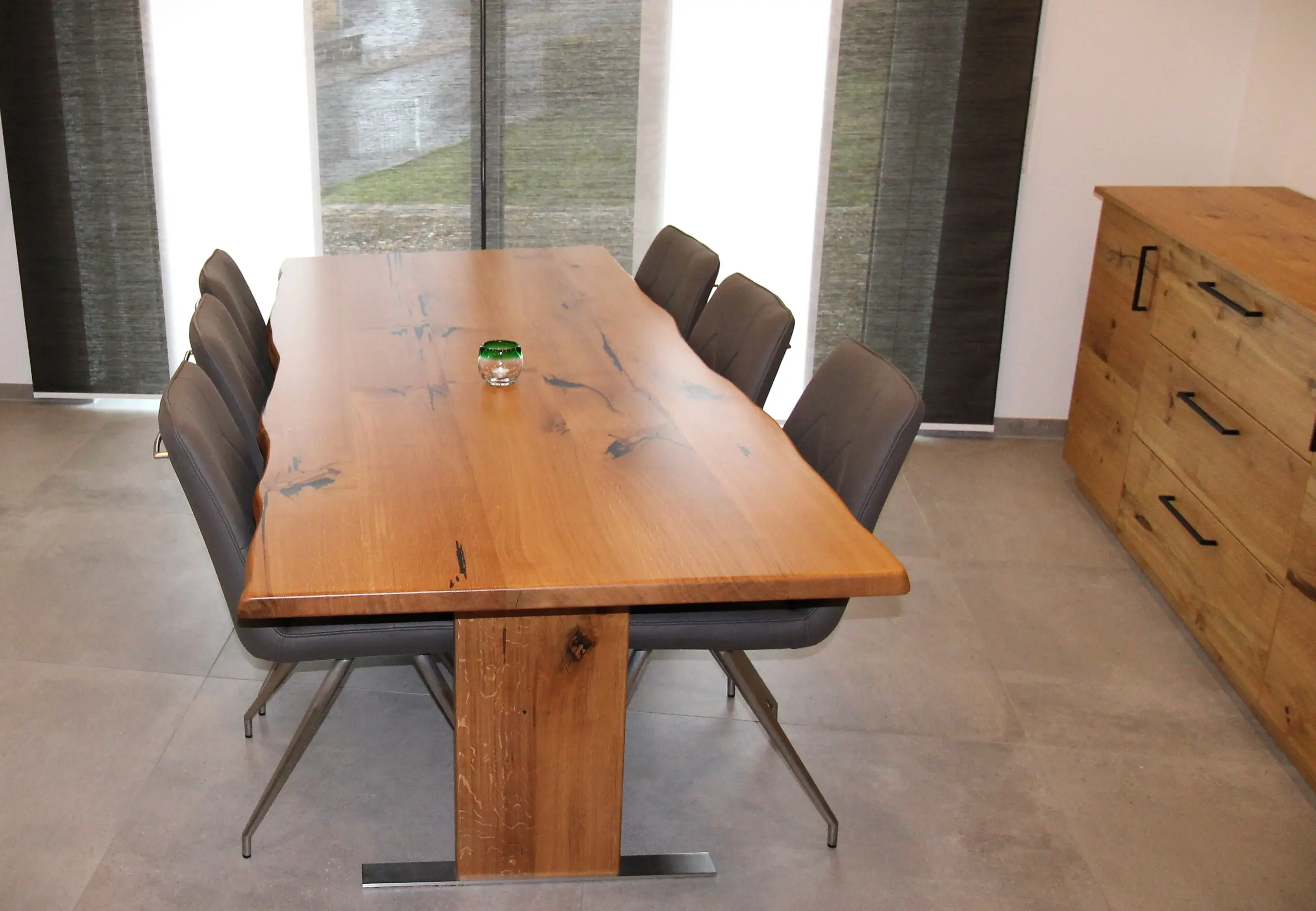 Holztisch mit sechs schwarzen Stühlen in modernem Esszimmer