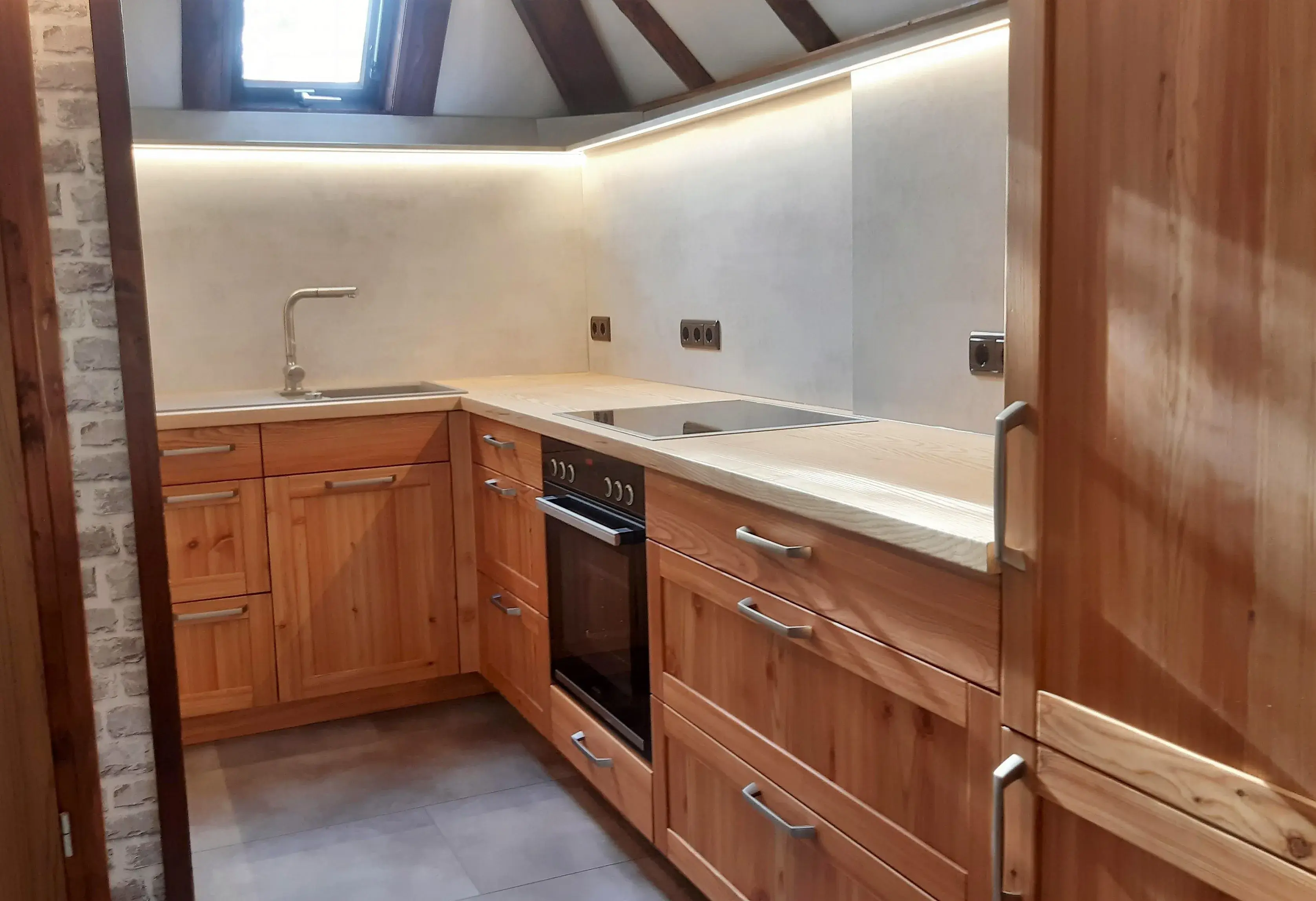 Moderne Holzküche mit Einbauherd, Spüle und Oberlicht.