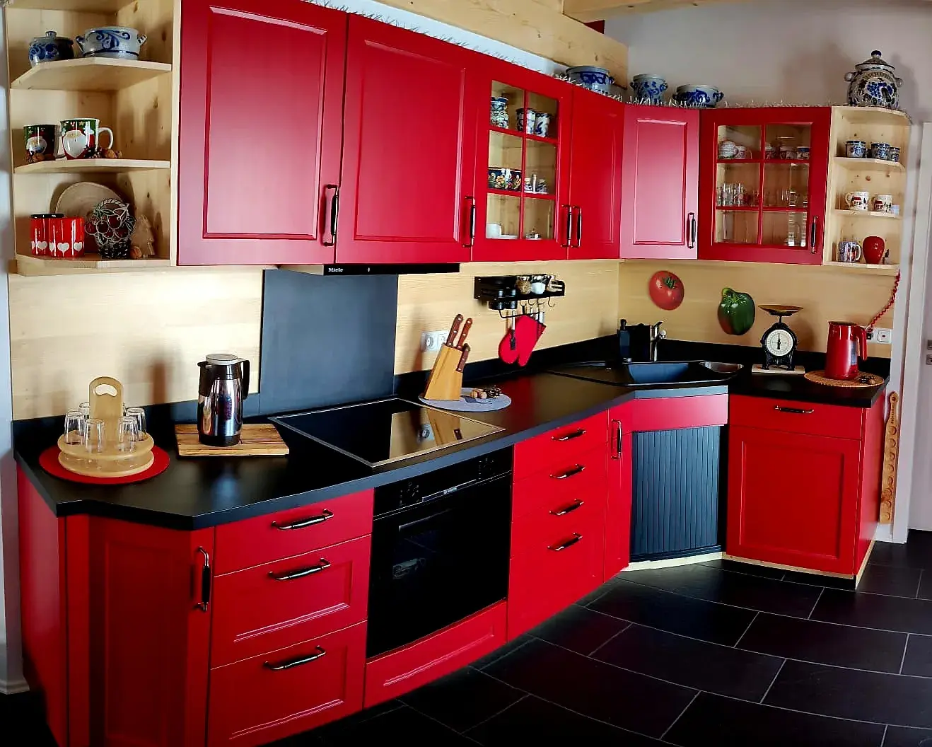 Küche in rubinrot mit schwarzer Arbeitsplatte